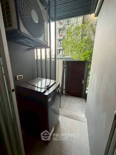 Modern apartment balcony with washing machine and air conditioning unit.