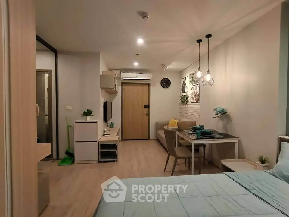Modern studio apartment with stylish decor and open layout, featuring cozy living area and dining space.