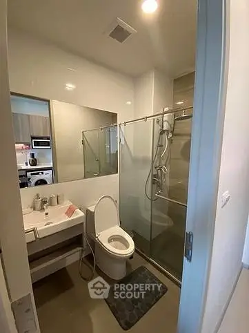 Modern bathroom with glass shower and sleek fixtures in a contemporary apartment.