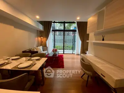 Modern living room with elegant dining area and large window view.