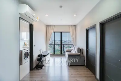 Modern living room with city view, featuring sleek furniture and natural light.