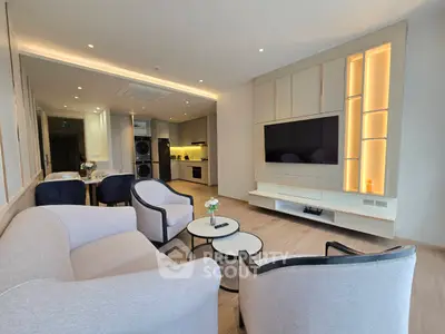Modern living room with open kitchen, stylish furniture, and integrated appliances in a contemporary apartment.