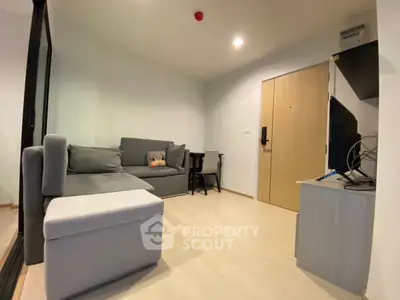 Modern living room with gray sofa and wooden flooring in cozy apartment.