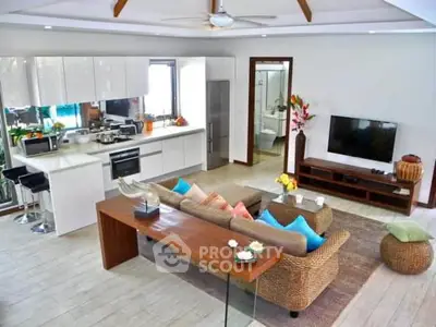 Spacious open-plan living room with modern kitchen and cozy seating area.