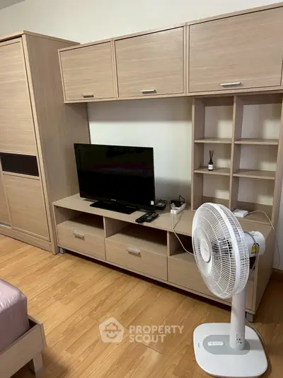 Modern bedroom with wooden furniture and TV setup