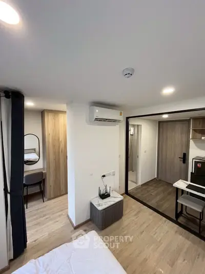 Modern studio apartment with sleek design and air conditioning, featuring a cozy workspace and stylish decor.