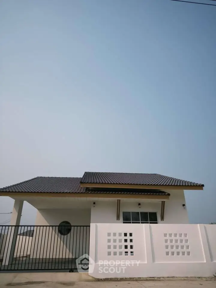 Charming modern house with sleek roof design and stylish fence, perfect for contemporary living.