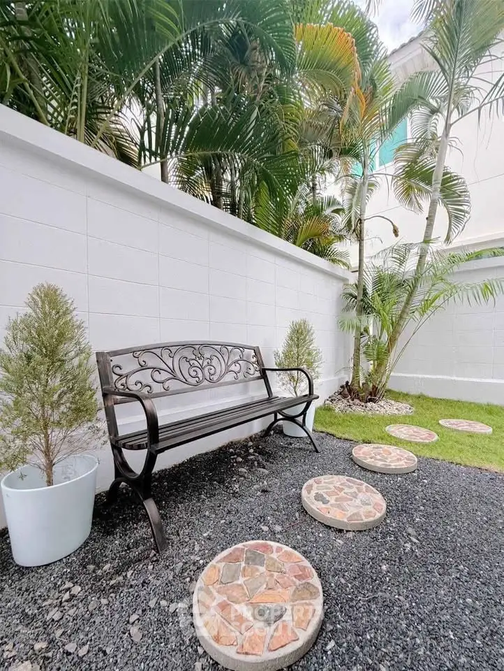 Charming garden area with decorative bench and stepping stones, perfect for relaxation and outdoor enjoyment.