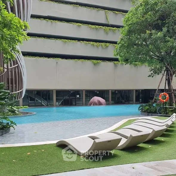 Luxurious poolside area with modern lounge chairs and lush greenery