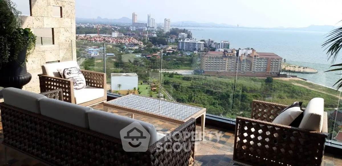Luxurious balcony with stunning ocean view and elegant outdoor seating area.
