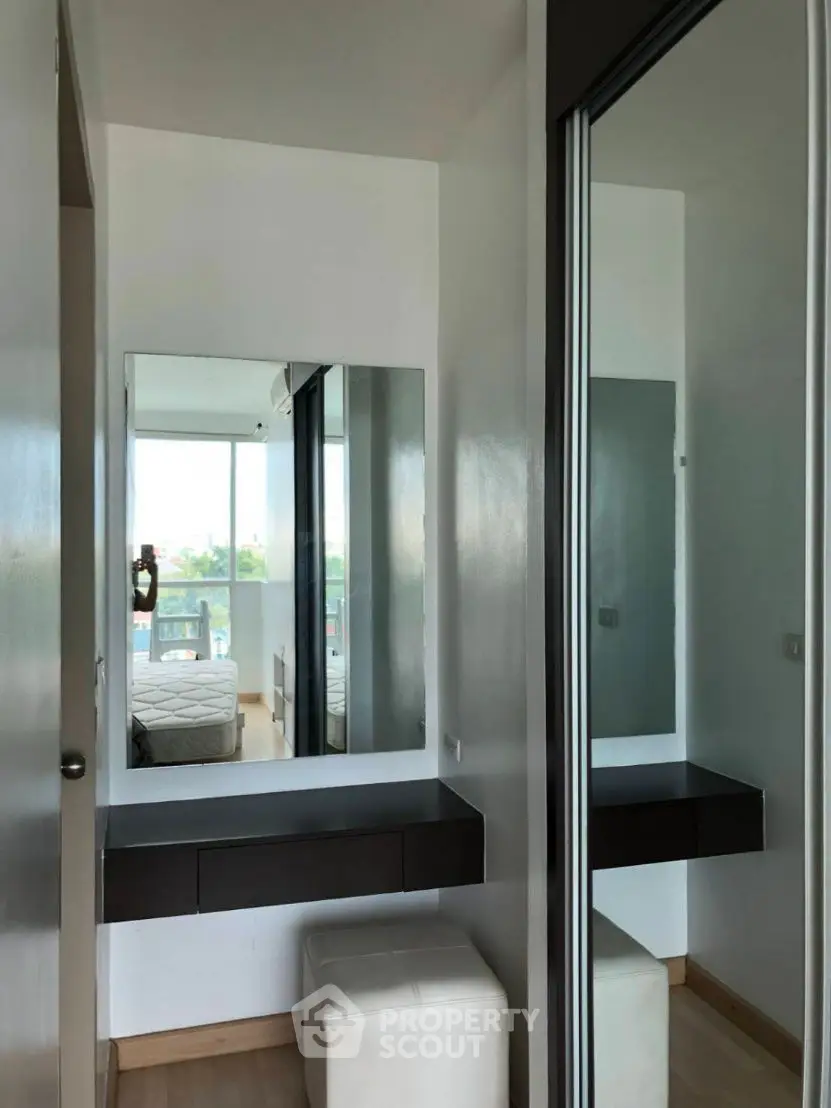 Modern bedroom with mirrored vanity and natural light