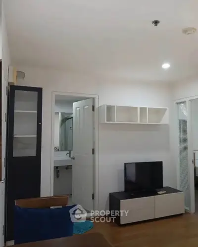 Modern living room with TV and open bathroom view in stylish apartment