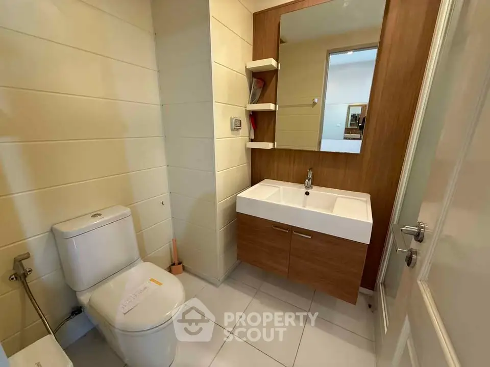 Modern bathroom with sleek vanity and large mirror in a stylish home.
