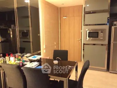 Modern kitchen with sleek appliances and dining area in stylish apartment.
