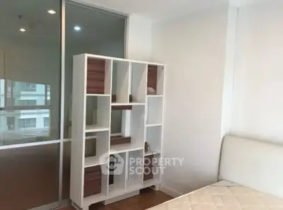 Modern bedroom with stylish shelving and comfortable bed in bright apartment