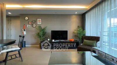Modern living room with stylish decor and large windows offering natural light.