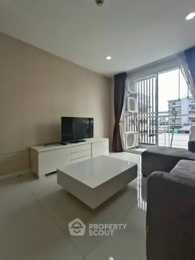 Modern living room with sleek furniture and large window offering city view