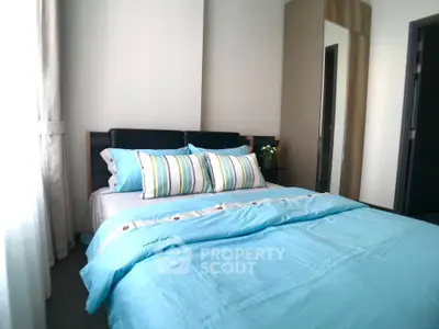 Cozy bedroom with stylish bedding and ample natural light, perfect for relaxation and comfort.