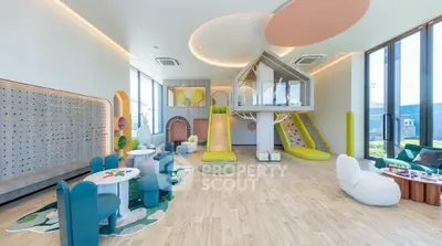 Modern children's playroom with climbing wall and slide in luxury residential building.