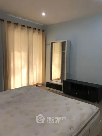 Cozy bedroom with natural light, featuring a comfortable bed and modern furniture, ideal for relaxation.
