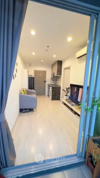 Modern open-plan living room with kitchen and balcony view
