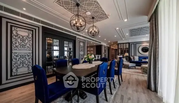 Luxurious dining and living area with elegant decor and modern lighting fixtures.