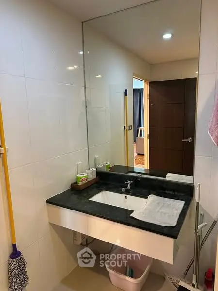 Modern bathroom with sleek sink and large mirror in a stylish apartment.
