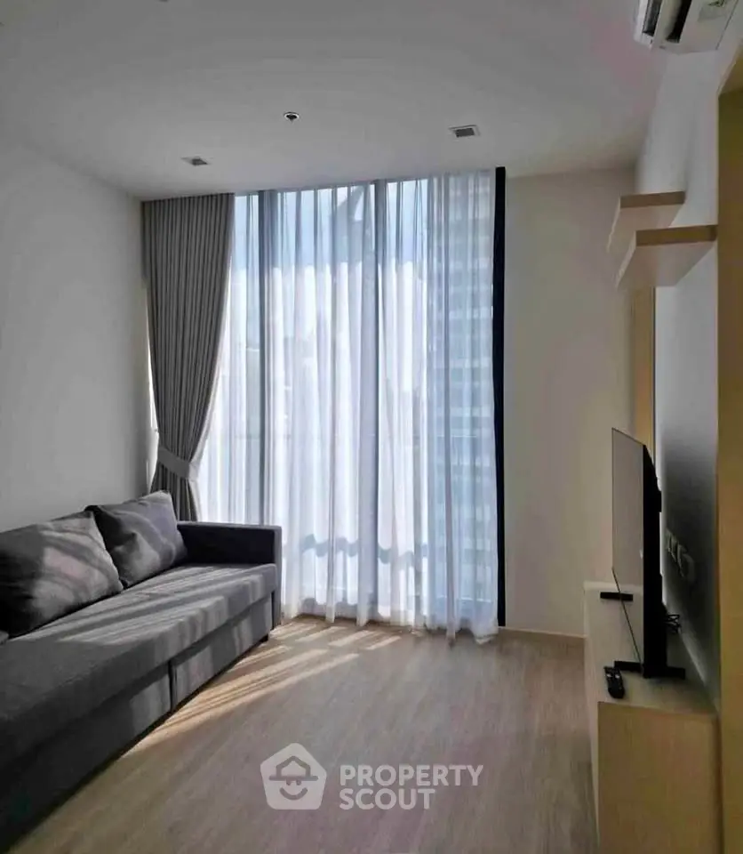 Modern living room with large window and stylish sofa in a bright apartment.
