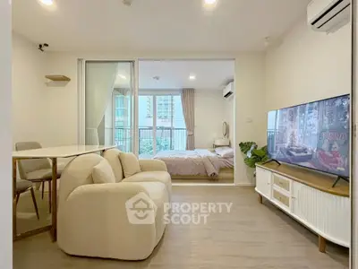 Modern open-plan living room with cozy seating and bedroom view