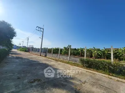 Spacious land plot with clear blue sky and lush greenery, ideal for development.