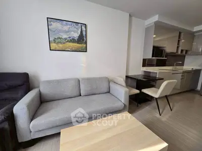 Modern living room with cozy gray sofa and stylish kitchen area, perfect for urban living.