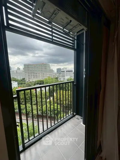 Stunning city view from modern balcony with lush greenery and urban skyline.