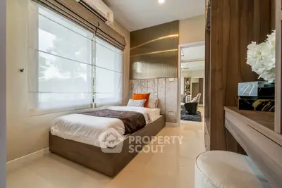 Modern bedroom with sleek design and natural light, featuring a cozy single bed and stylish decor.