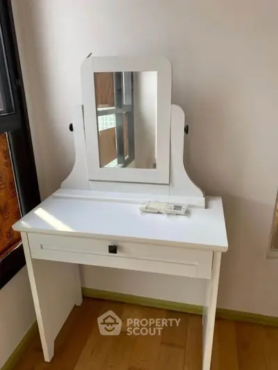 Charming white vanity table with mirror in a cozy bedroom setting, perfect for elegant interior design.