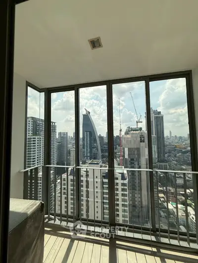 Stunning cityscape view from a high-rise balcony with modern glass railing.