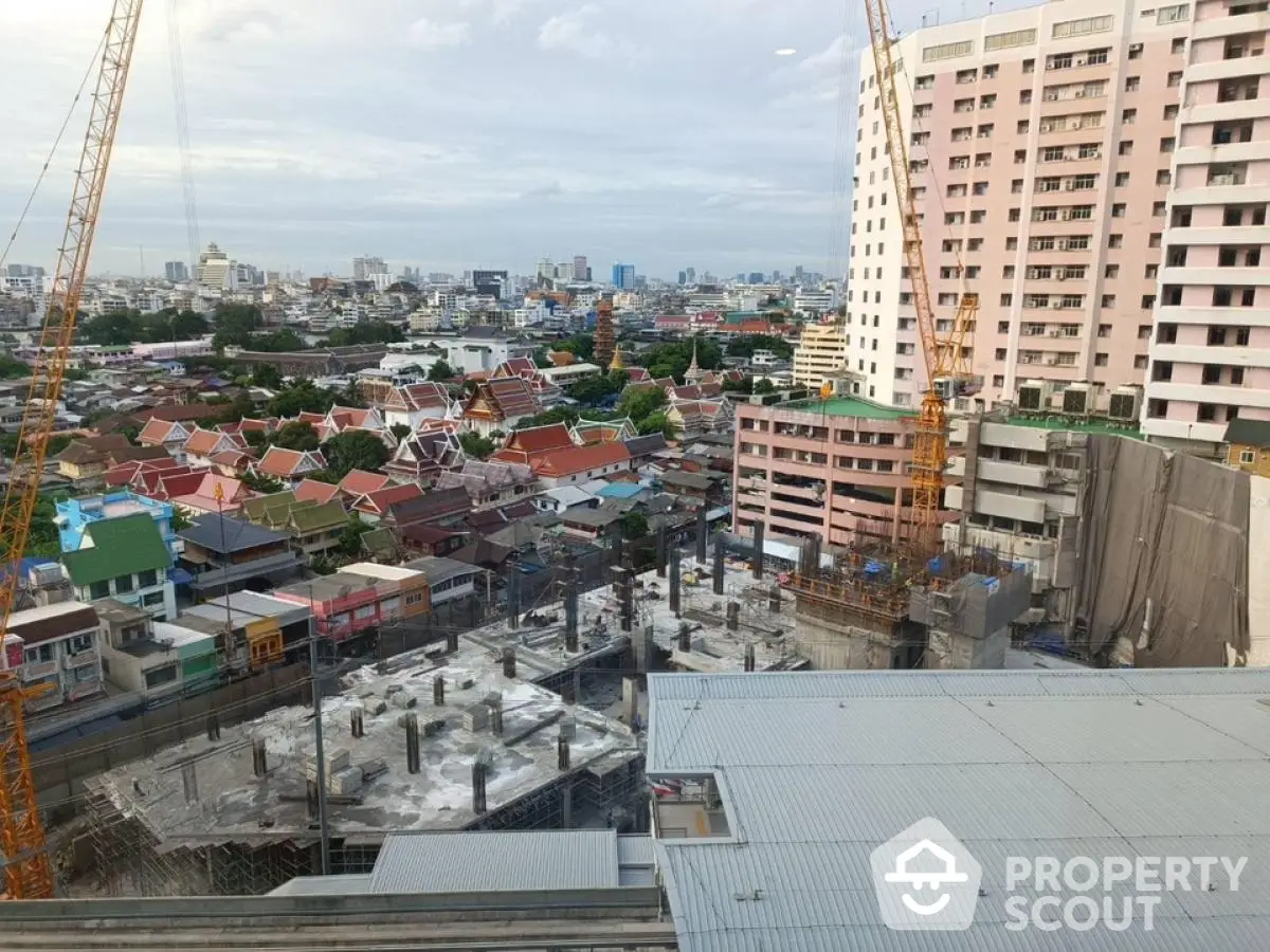 Urban construction site with cranes and city skyline view