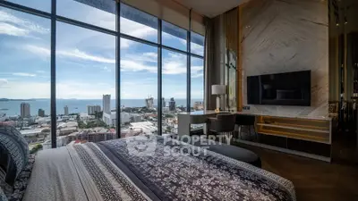 Luxurious bedroom with stunning city and ocean view through floor-to-ceiling windows.