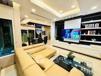 Luxurious modern living room with elegant decor and spacious layout, featuring a large TV and stylish furniture.