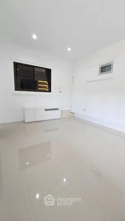 Spacious minimalist room with glossy tiled floor and modern white interior design.