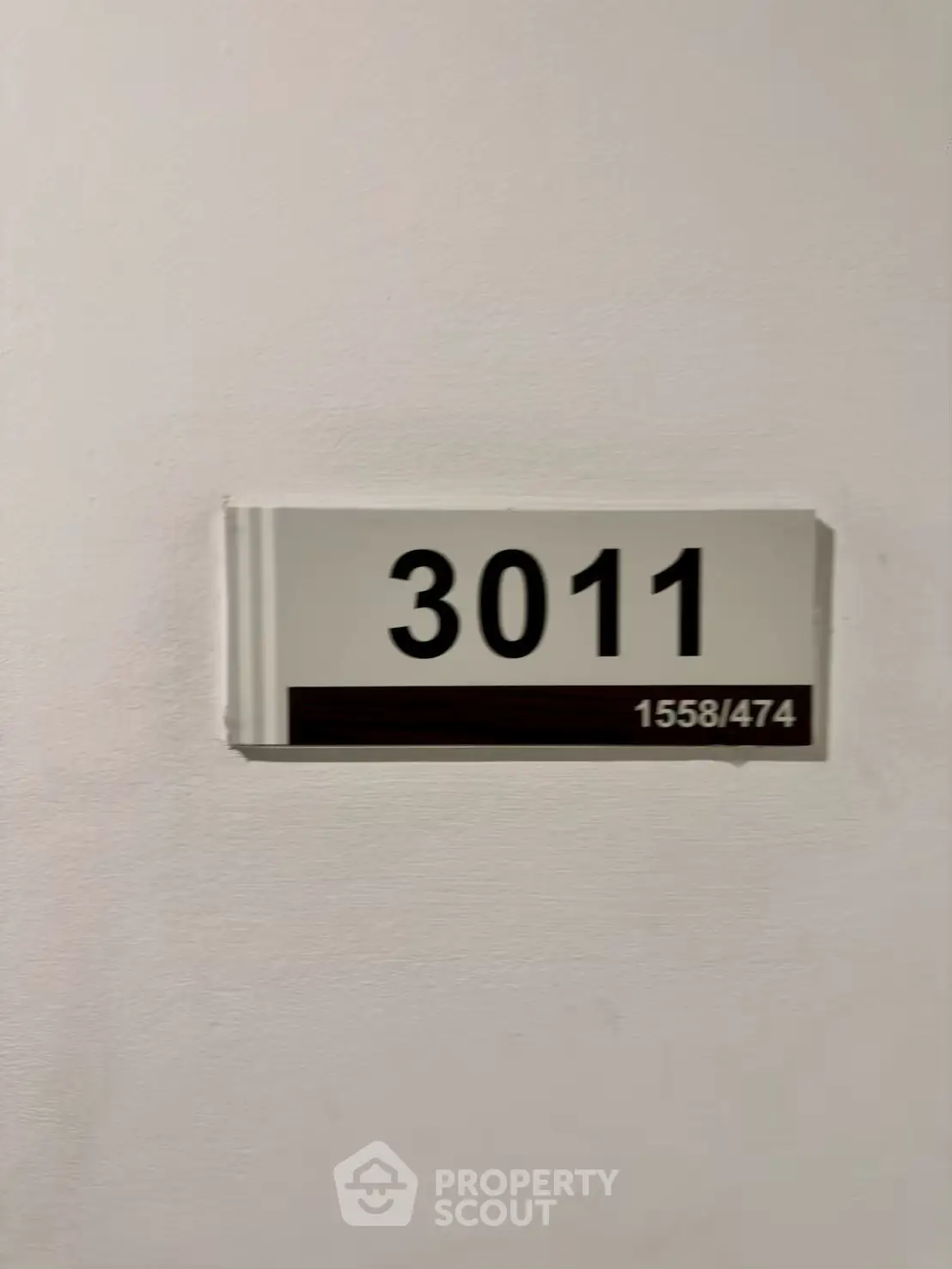 Apartment door number 3011 on a white wall, indicating unit location.
