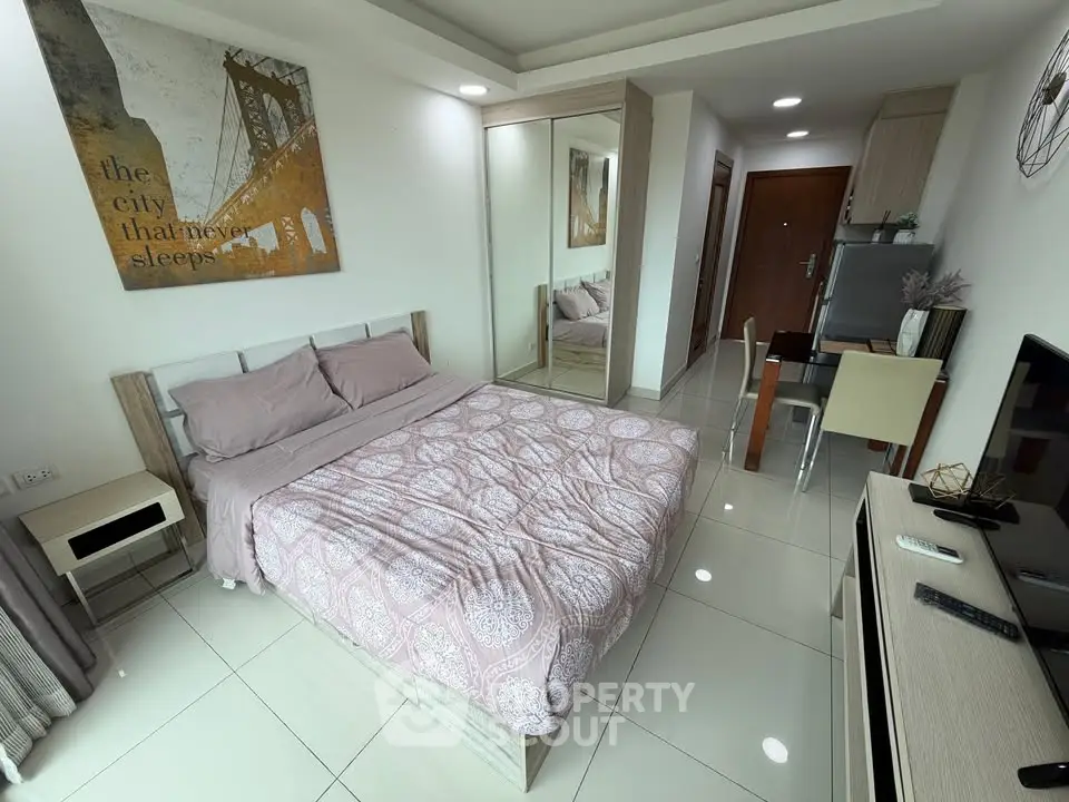 Modern bedroom with stylish decor and mirrored wardrobe in a cozy apartment.