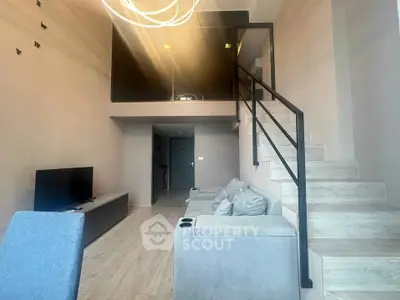 Modern loft-style living room with high ceiling and stylish staircase