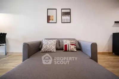 Modern living room with stylish gray sofa and decorative pillows, perfect for cozy relaxation.
