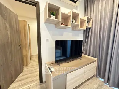Modern living room with stylish TV stand and wall shelves, featuring elegant decor and natural light.