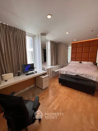 Spacious modern bedroom with study area and large windows