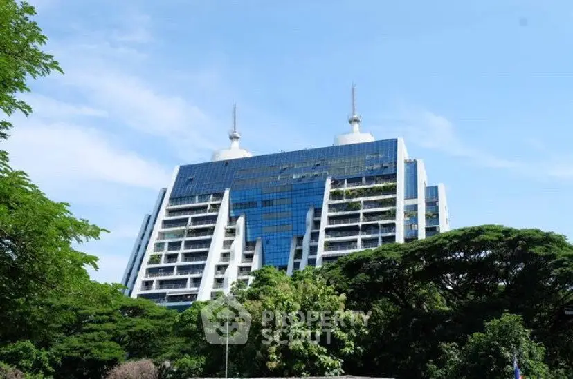 Stunning modern building with unique architecture and lush greenery surroundings.