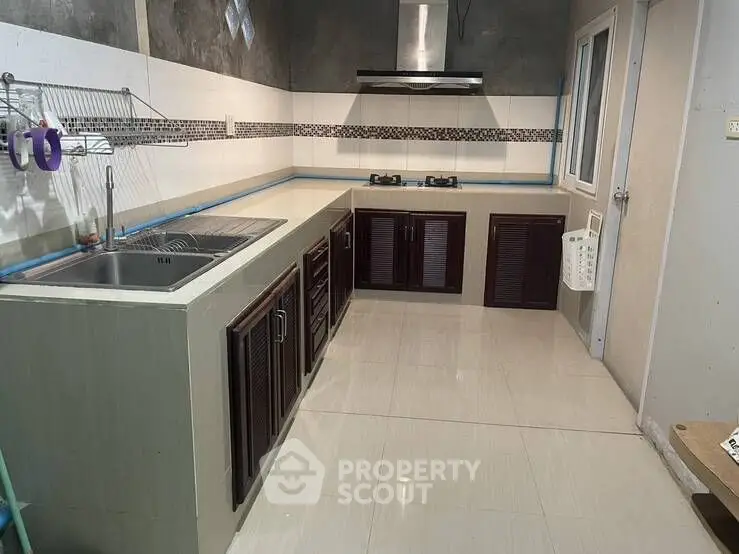 Modern kitchen with sleek cabinetry and gas stove in a cozy home setting.