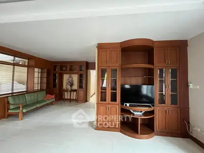 Spacious living room with elegant wooden cabinetry and modern TV setup