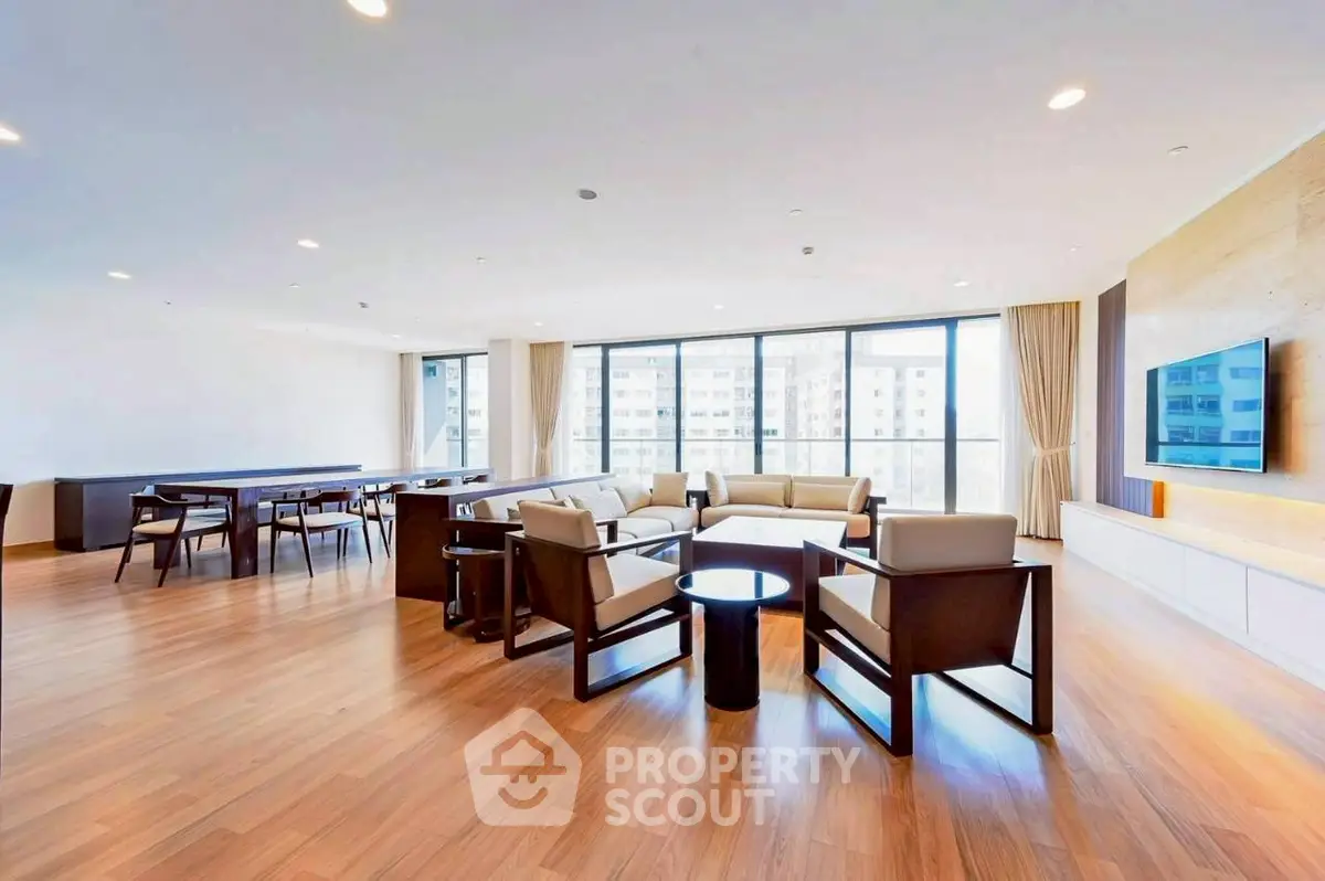 Spacious modern living room with large windows and elegant furnishings.