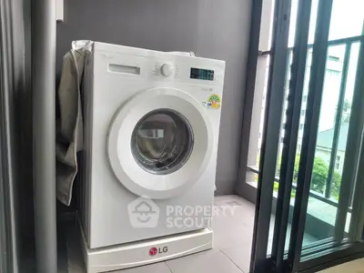 Modern washing machine on a balcony with city view, perfect for urban living convenience.